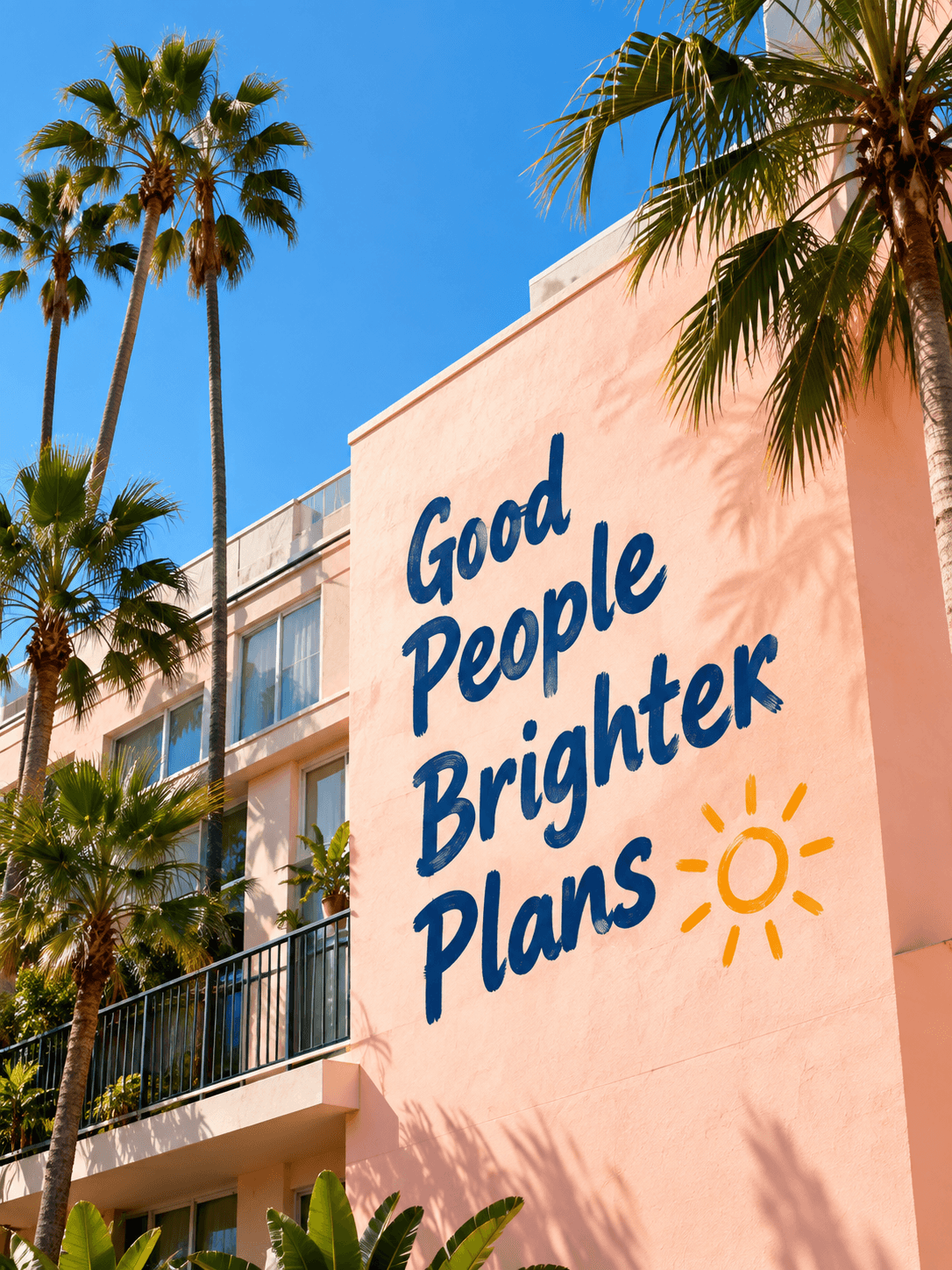 Palm trees and a peach building with the mural Good People Brighter Plans